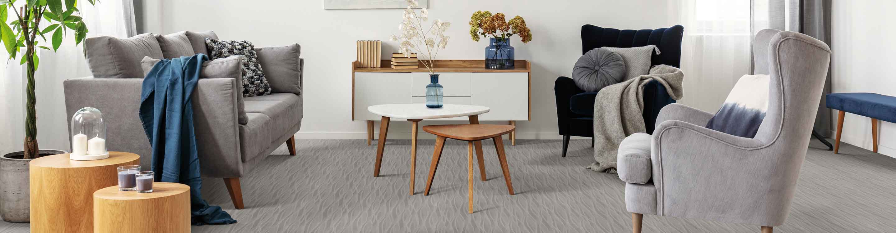 patterned gray carpet modern living room with gray couch and two chairs and wood accents