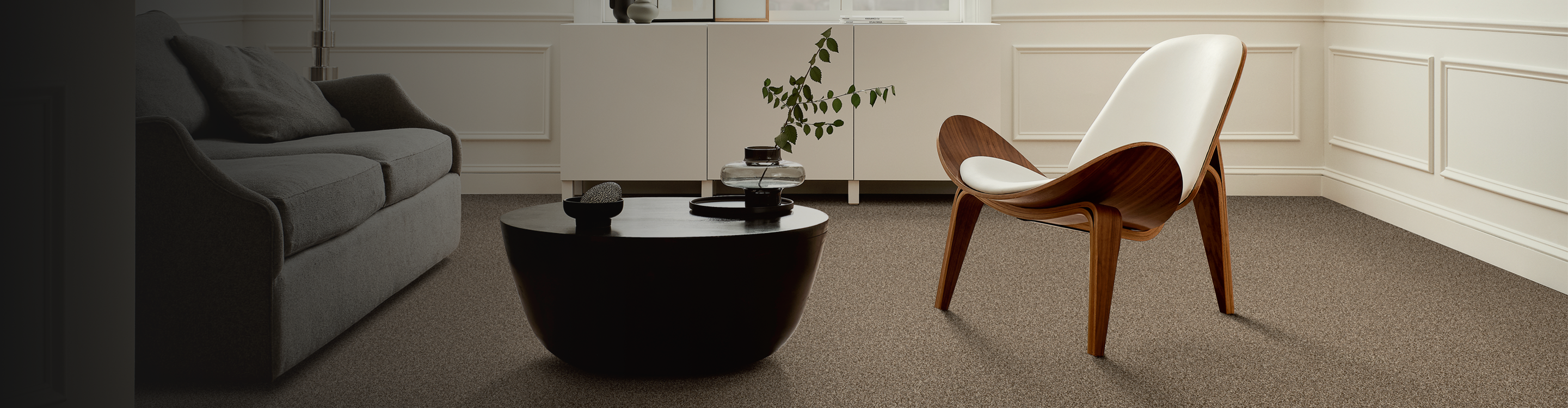 Brown carpet in a living room with a wooden accent chair